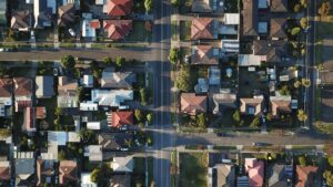 Aerial view of suburban neighborhood streets and houses in sunlight.